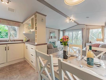 a kitchen and dining area with a table set for four at Kelling Heath Holiday Park - Holiday Accommodation 19668 in Holt