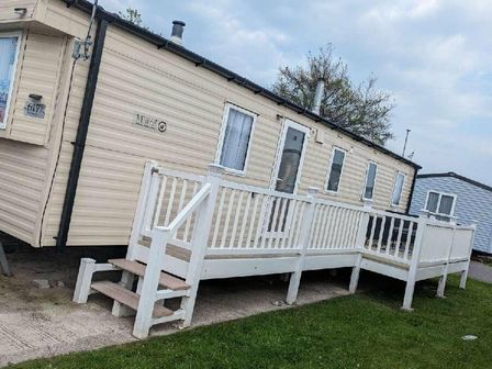 a caravan with a white deck and steps at Lyons Winkups and Primrose - Holiday Accommodation 19674 Towyn
