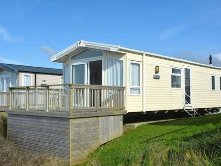 a mobile home with a wooden deck and steps at Perran Sands - Holiday Accommodation 19778 in Perranporth