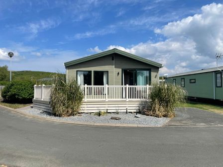 a holiday home with a deck and greenery at Greenacres Holiday Park - Holiday Accommodation 2006, Porthmadog