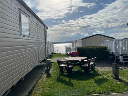 a view of mobile homes with a picnic table and waterfront at Rockley Park - Holiday Accommodation 20106 Poole