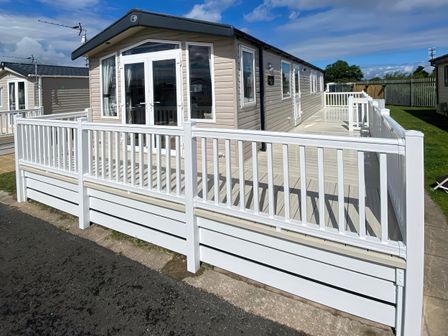An outdoor area with a holiday home and decking at Marine Holiday Park - Holiday Accommodation 20147, Rhyl