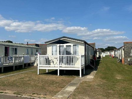 a row of holiday caravans with a grassy area in front at Highfield Grange - Holiday Accommodation 20216, Clacton-on-Sea