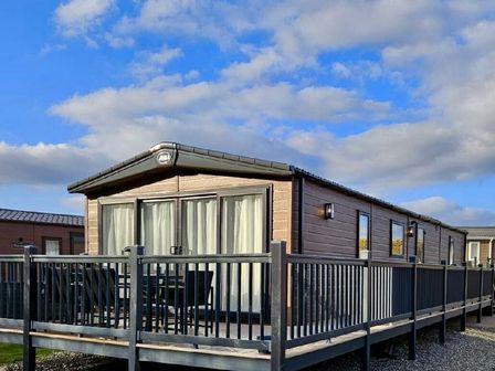 a holiday cabin with a deck and patio furniture at Hafan y Mor Haven - Holiday Accommodation 20306 in Pwllheli