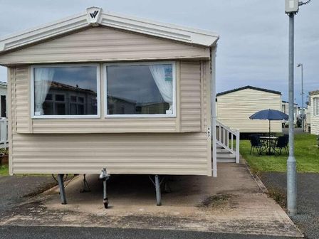 a caravan with a front porch and outdoor seating area at Edwards Leisure Park - Holiday Accommodation 20407, Towyn, Abergele