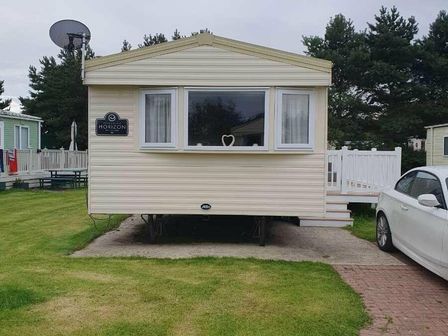 a static caravan with a sign and a window at Hafan y Mor Haven - Holiday Accommodation 20408 Pwllheli