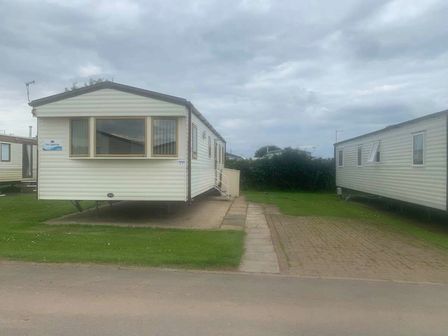 a static caravan parked on a grassy area at Skipsea Sands Holiday Park - Holiday Accommodation 20647, Skipsea