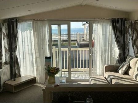 a living room with large windows and a view of the sea at Golden Sands Kinmel Bay - Holiday Accommodation 20780 in Kinmel Bay