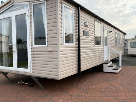 A mobile home with windows and steps at Lyons Robin Hood - Holiday Accommodation 20871 Rhyl