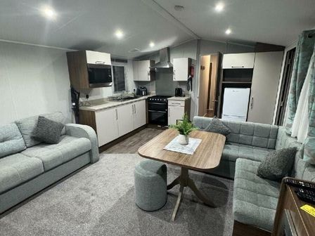 a living room with a kitchen area featuring sofas and a dining table at Butlins Skegness - Holiday Accommodation 21028 in Skegness