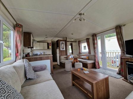 a living room with sofas, a coffee table, and a kitchen area at Clarach Bay Holiday Village - Holiday Accommodation 21090 in Aberystwyth