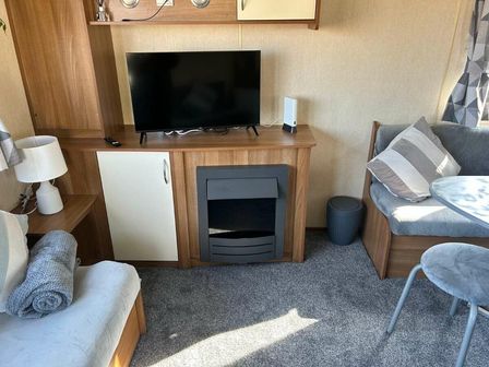 a living area with a television, a fireplace, a seating area, and a round table at Southview Holiday Park - Holiday Accommodation 21385 in Skegness