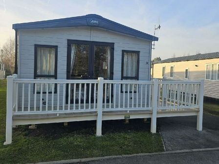 a mobile home with a porch and windows at Tattershall Lakes Country Park - Holiday Accommodation 21501 in Tattershall
