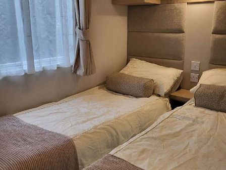 a bedroom with two single beds and a window at Swanage Bay View - Holiday Accommodation 21567, Swanage
