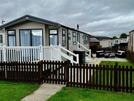 a holiday caravan with a porch, steps, and outdoor seating at Unity Holiday Resort - Holiday Accommodation 21577, Burnham-on-Sea
