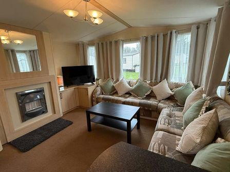 a living room with a television, fireplace, and seating area at Haggerston Castle - Holiday Accommodation 21621 Beal