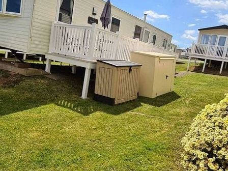 a garden area with two storage units near caravans at Devon Cliffs Holiday Park - Holiday Accommodation 21622 in Exmouth