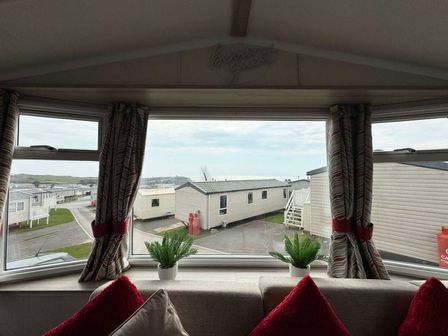 a window view of residential mobile homes with plants on a windowsill at Devon Cliffs Holiday Park - Holiday Accommodation 21623 Exmouth