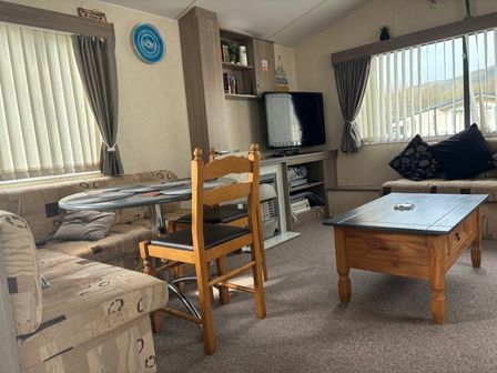 a living room with a sofa, table, and television at Clarach Bay Holiday Village - Holiday Accommodation 21657 Aberystwyth
