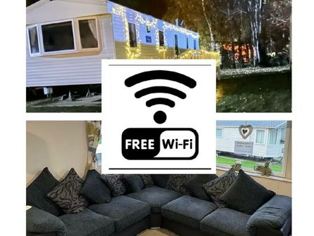 a holiday caravan with lights outside and a cozy sitting area inside at Seton Sands Caravan Park - Holiday Accommodation 21913, Seton Sands