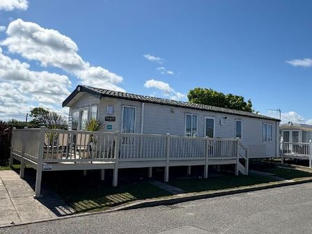 a holiday home with a wooden deck and a clear blue sky at Golden Sands Kinmel Bay - Holiday Accommodation 21939 in Kinmel Bay