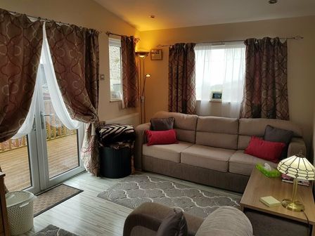 a living room with a sofa and curtains at West View Caravan Park - Holiday Accommodation 2197 in Kendal