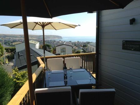 a balcony with a table and chairs overlooking the sea at Swanage Bay View - Holiday Accommodation 22045 in Swanage
