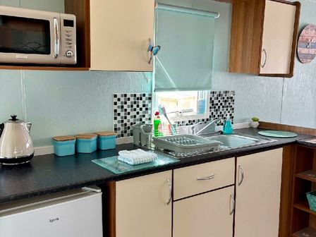 a kitchen with a sink and cabinets at Valley Farm Holiday Park - Holiday Accommodation 22153 Clacton-on-Sea