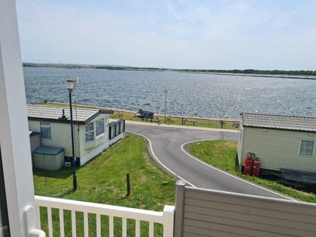 a view of a waterbody with caravans nearby at Port Haverigg Holiday Village - Holiday Accommodation 22232 in Millom