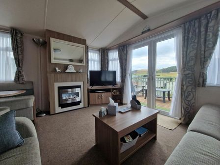 a living room with a television, fireplace, and sofa at Clarach Bay Holiday Village - Holiday Accommodation 22248, Aberystwyth