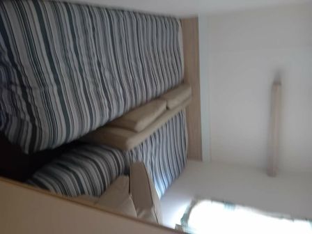 two beds with striped bedding in a room at Lyons Robin Hood - Holiday Accommodation 22281 in Prestatyn