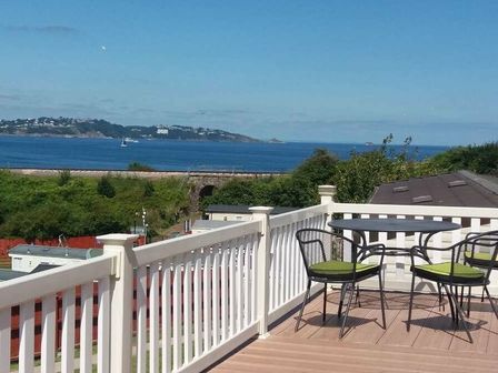 a balcony with a table and chairs overlooking the sea at Waterside, Paignton - Holiday Accommodation 2287, Paignton