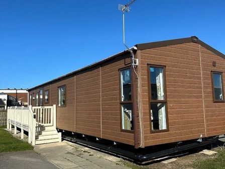 a brown holiday home with stairs and windows at Cala Gran Holiday Park - Holiday Accommodation 3068 Fleetwood