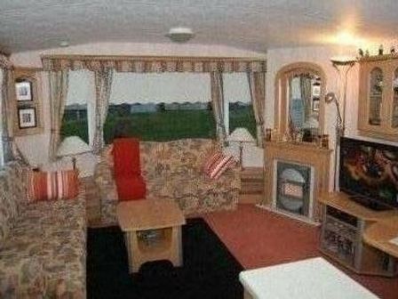 a living room with a sofa, armchairs, coffee table, and television at Edwards Leisure Park - Holiday Accommodation 318 Towyn