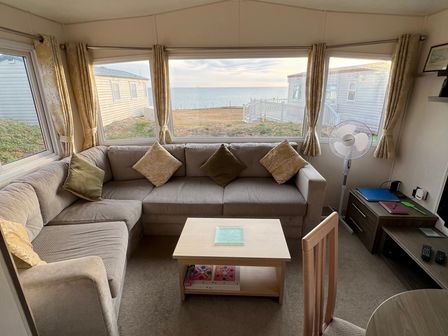 A living room with a sofa and table at Kiln Cliffs Caravan Park - Holiday Accommodation 432 in Mundesley