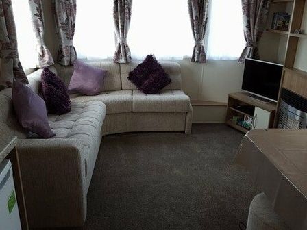 a seating area with a corner sofa, cushions, and a television at Harlyn Sands - Holiday Accommodation 5918 in Padstow