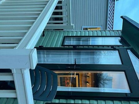 a balcony with a chair and view of the exterior of a green building at Presthaven Beach Resort - Holiday Accommodation 628 in Prestatyn