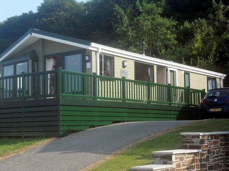 a holiday home with a green deck and a car parked nearby at White Acres Holiday Park - Holiday Accommodation 6776 in Newquay