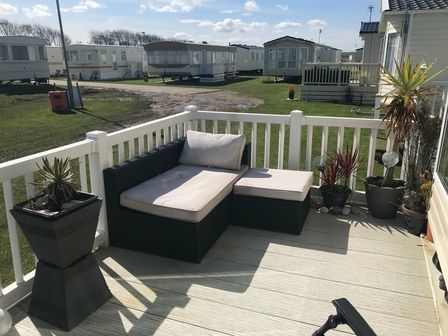 a seating area with a couch on a deck at Lido Beach Holiday Park - Holiday Accommodation 7253, Prestatyn