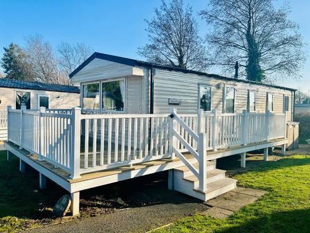 a holiday home with a wooden deck and steps at Hafan y Mor Haven - Holiday Accommodation 7421 Pwllheli