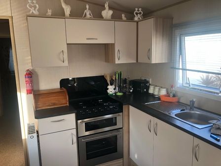 a kitchen with cabinets and appliances including a stove and sink at Trecco Bay - Holiday Accommodation 7489 Porthcawl