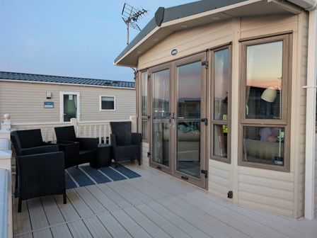 a deck area with seating and a view at Greenacres Holiday Park - Holiday Accommodation 7656 in Porthmadog