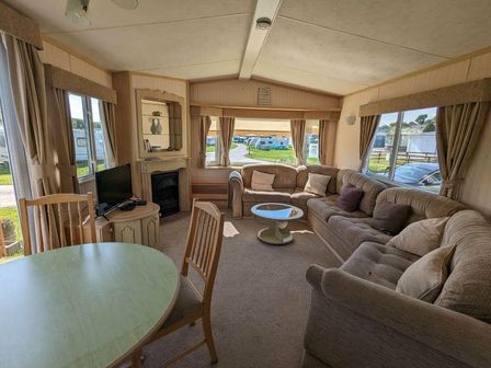 a living room with a sofa, coffee table, and dining table at Aberystwyth Holiday Village - Holiday Accommodation 8277, Aberystwyth