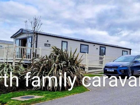 a caravan with a parking area and a car in front at Reighton Sands Holiday Park - Holiday Accommodation 9333 in Filey
