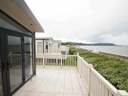 a deck overlooking the sea with holiday homes at Hoburne Blue Anchor - Holiday Accommodation 9444 Minehead