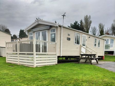 A mobile home with decking and steps at Beverley Bay Holiday Park - Holiday Accommodation 9506 Paignton