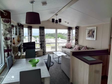 a living room with a sofa and dining table at Brynowen Holiday Park - Holiday Accommodation 9957, Borth