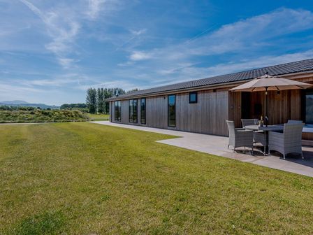A building with seating area and grass at Wordsworth in Wigton