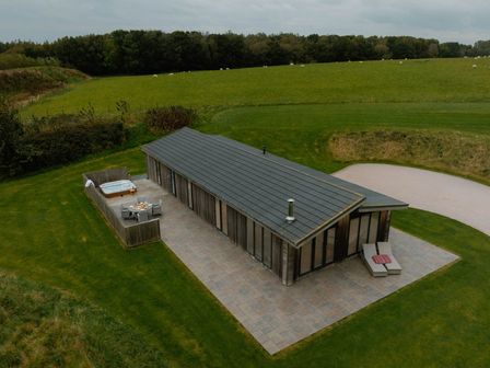A hut with a hot tub and patio furniture at Wellington in Wigton