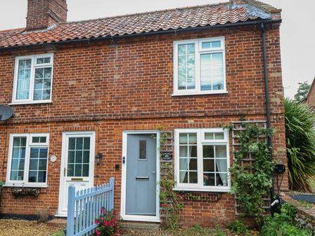A brick exterior of a house with windows and a front door at Beeble Cottage in Fakenham
